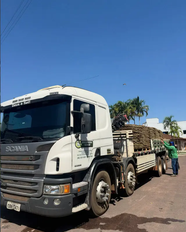 Caminhão da Grameira Sinop com guindaste, carregado de placas de grama